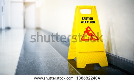 Sign showing warning of caution wet floor on wet tile floor
