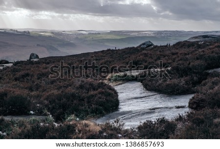 Beautiful moody landscape picture of the Peak District National Park with a heavy storm clouds