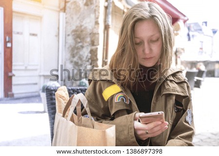 girl traveler sits in a cafe with a smartphone. Morlaix, France
