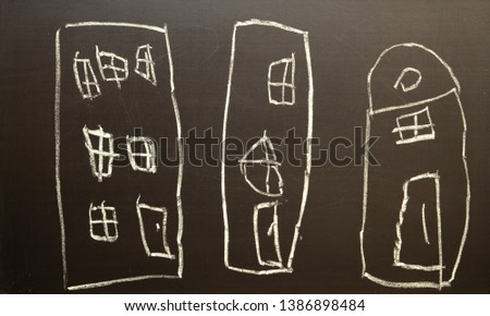 Children's drawing of houses drawn in chalk on a black board
