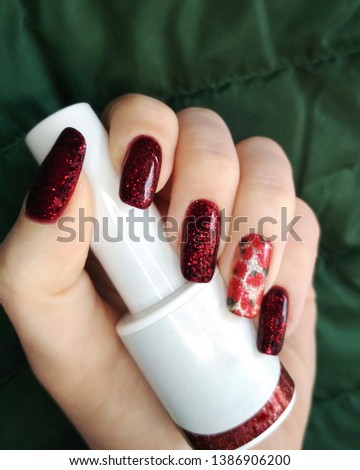 Woman hand finger black and red flower manicure gel nail polish swatch design white bottle beauty fashion photo