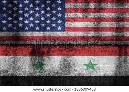 two flags on a cracked wall, USA and Syria
