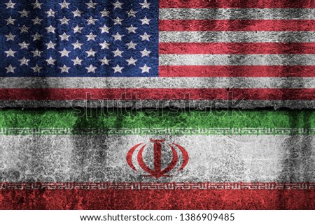 two flags on a cracked wall, USA and Iran
