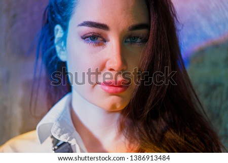 Young beautiful woman under bright multicoloured light in ancient church.