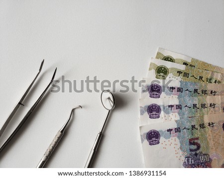 dentist utensils for oral review and chinese banknotes 