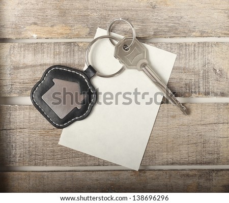  Key with house icon on wooden background