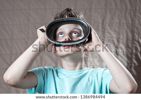 boy in a swimming mask looking up from the water