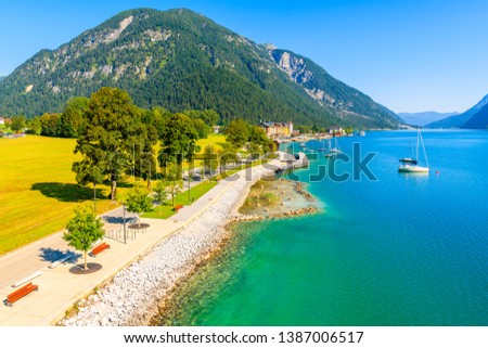 View of beautiful Achensee lake and boats on sunny summer day with blue sky, Karwendel mountain range, Tyrol, Austria Royalty-Free Stock Photo #1387006517