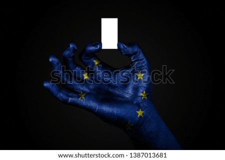 hand with a painted flag EU holding a small white sheet with space for an inscription, mock up. Horizontal frame