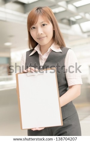 Asian business woman hold a blank board in modern city.