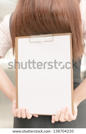 Rear view of Asian business woman hold a blank board.