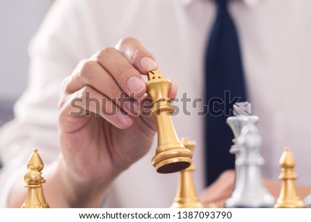 victory leader and success concept, business man playing take a checkmate figure another king with team on the chess board and thinking about strategy or management intelligence and education.