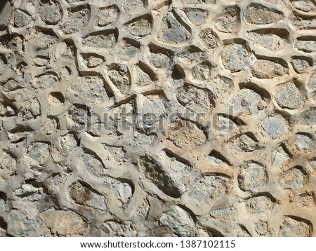 Cement Plastered Rubble Stone Masonry of a Retaining Wall on a High Pitched Slope forming an Abstract Pattern