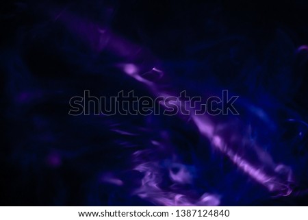 projector spotlight purple color , abstract smoke texture background . light beam screening and glowing in dark black room at night .