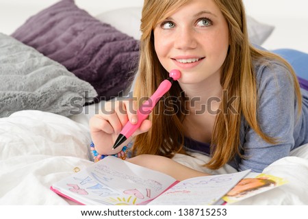 Daydreaming teenager girl writing her journal about a boy Royalty-Free Stock Photo #138715253