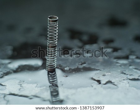 metal spring isolated on black background with reflection. Macro photography