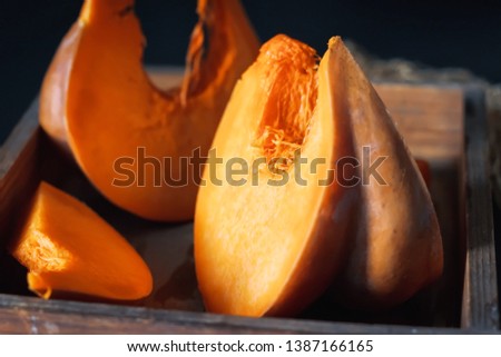 Fresh juicy pumpkin. Sliced ​​raw orange pumpkin in a vintage wooden pulp on a table against a dark background. Mill food. . Food stock photography. Healthy food. food photography - Image