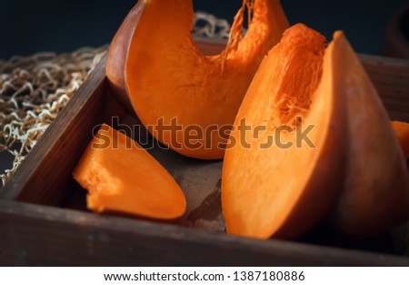 Fresh juicy pumpkin. Sliced ​​raw orange pumpkin in a vintage wooden pulp on a table against a dark background. Mill food. . Food stock photography. Healthy food. food photography - Image