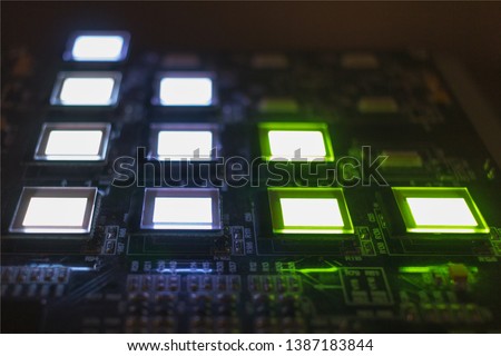 The process of checking several oled displays on the test station. Displays glow brightly of green and white color close up. Royalty-Free Stock Photo #1387183844