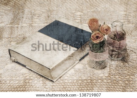 layered with grungy style photo of unnamed book and bottles of flowers