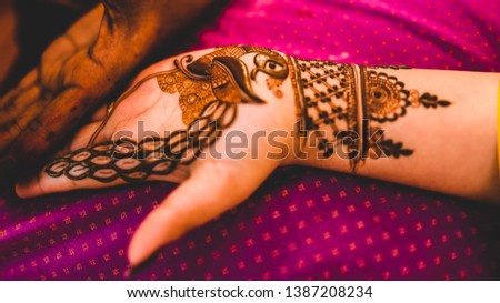 henna tattoo being applied on a women's hand.