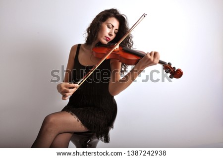 woman closed eyes playing violin  Royalty-Free Stock Photo #1387242938