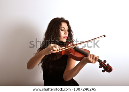woman closed eyes playing violin Royalty-Free Stock Photo #1387248245