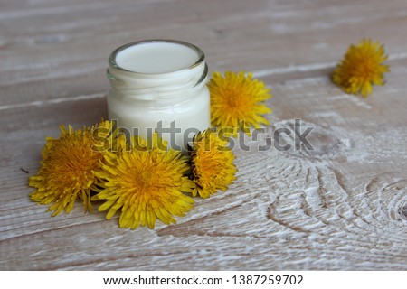 Organic face cream with dandelion flowers