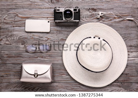 Female accessories with photo camera and mobile phone on wooden background. Travel concept