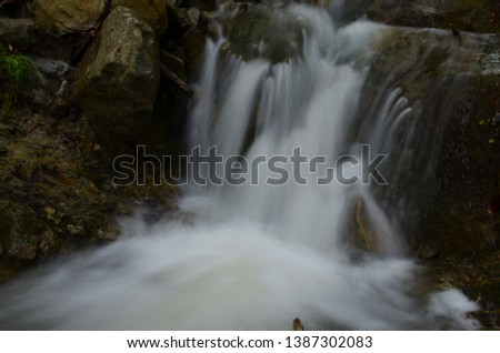 beautiful waterfall with clear water on a mountain stream in the forest after rain