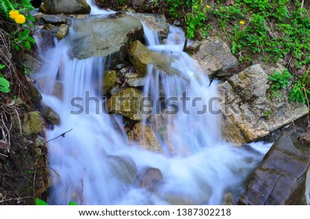 beautiful waterfall with clear water on a mountain stream in the forest after rain