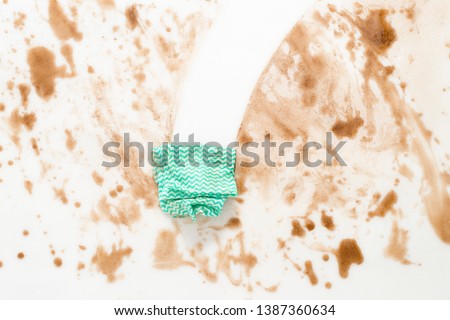 Green cloth or rag wiping clean a dirty counter top or floor Royalty-Free Stock Photo #1387360634