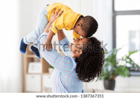 childhood, kids and people concept - happy african american mother with her baby son at home Royalty-Free Stock Photo #1387367351