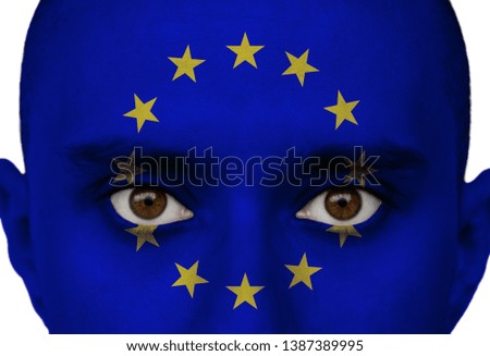 The colored blue flag of the European Union is painted on the face of a man close up, concept