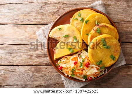 Salvadoran pupusa served with curtido closeup on a plate. horizontal top view from above
