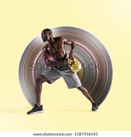 Young african-american bodybuilder training on yellow studio background. Muscular male model with the weight. Concept of sport, bodybuilding, healthy lifestyle, movement, action. Abstract design.