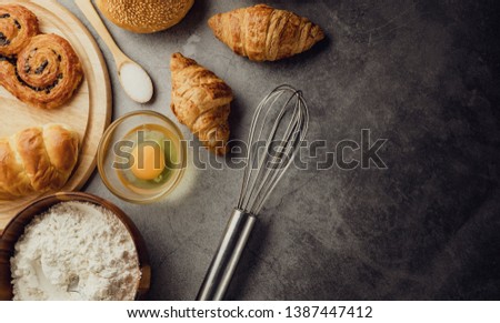 Freshly baked bread on wooden table,Bakery Concept- gold rustic crusty loaves of bread and buns on black chalkboard background. captured from above (top view, flat lay. Layout with copy space.