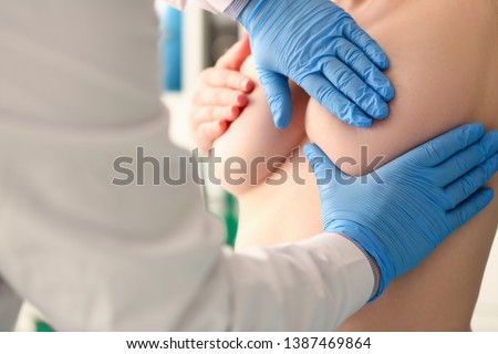 Doctor Mammologist Exam Patient Breast in Hospital. Medic Specialist in Blue Gloves Touch Topless Woman. Mammography and Oncology Consultation in Clinic. Healthcare Awarwness Prevent Cancer Concept Royalty-Free Stock Photo #1387469864