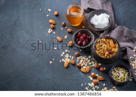 Healthy eating, dieting and nutrition, fitness, balanced food, breakfast concept. Homemade granola muesli with ingredients on a table. Copy space background