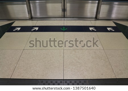 Arrows in front of the platform screen door in subway of Hong Kong 