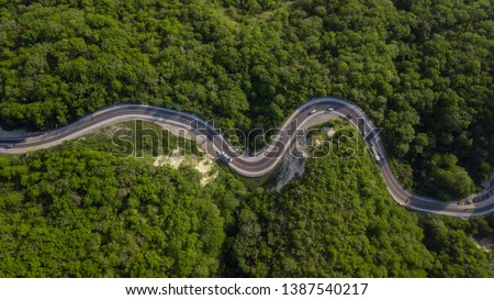 Aerial top down view: of cars driving on zig zag winding mountain road Royalty-Free Stock Photo #1387540217
