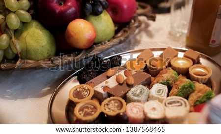 Close up for the traditional table with apples, grapes, pears and different oriental sweets with nuts, food and celebration concept. Stock. Delicious dishes with fruits and sweets.