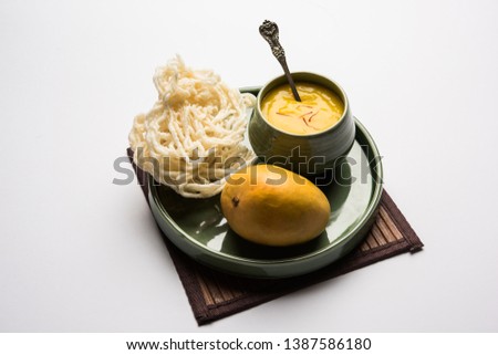 Aam Ras or Alphonso mango pulp with kurdai which is a fried dish made using wheat/gehu. selective focus