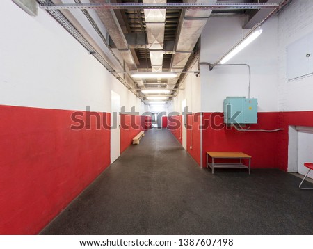 Long corridor, red white walls, doors, rubber floor for skates