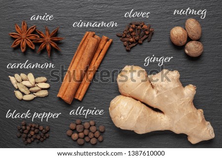 Gingerbread spices on slate - star anise, cinnamon, cloves, nutmeg, ginger, cardamom, black pepper, allspice