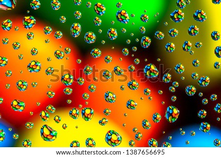 Macro picture of water drops on glass surface and colorful chocolate candies abstract background