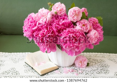 peony and roses flowers bunch in vase, still life with books and fruits, teacher's day concept	