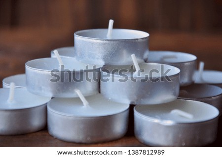 many small candles stacked in a pyramid on a wooden table