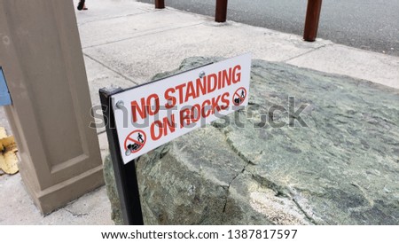 
No standing on rocks white sign