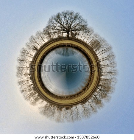 Tiny planet in the springtime with trees and their reflections in a lake in the center of the planet